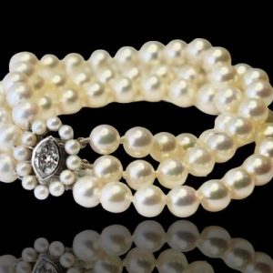 Antiek juweel armband bestaande uit drie strengen, 1e kwaliteit cultivé parels aan wit gouden slot met een markies geslepen diamant van 1.50 crt