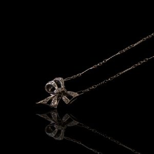 18 krt. wit gouden collier met strikje waarin roos geslepen diamantjes