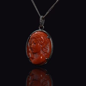 Zilveren hanger met een gesneden koraal camée, aan een zilveren collier