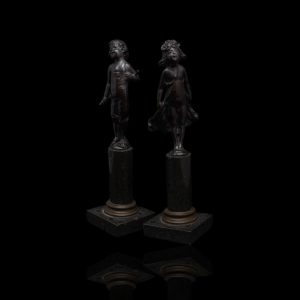 Twee bronzen beeldjes van een jongetje en een meisje op marmeren zuiltjes, gesigneerd, Paul Ludwig Kowalczewski