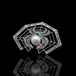 Zilveren broche in de vorm van een spin in een web, bezet met markasiet, parel en groen agaat