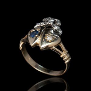 Antieke gouden Edwardiaanse ring met dubbel hart, bezet met saffier en briljant (oud slijpsel), afgewerkt met een strik bezet met diamanten